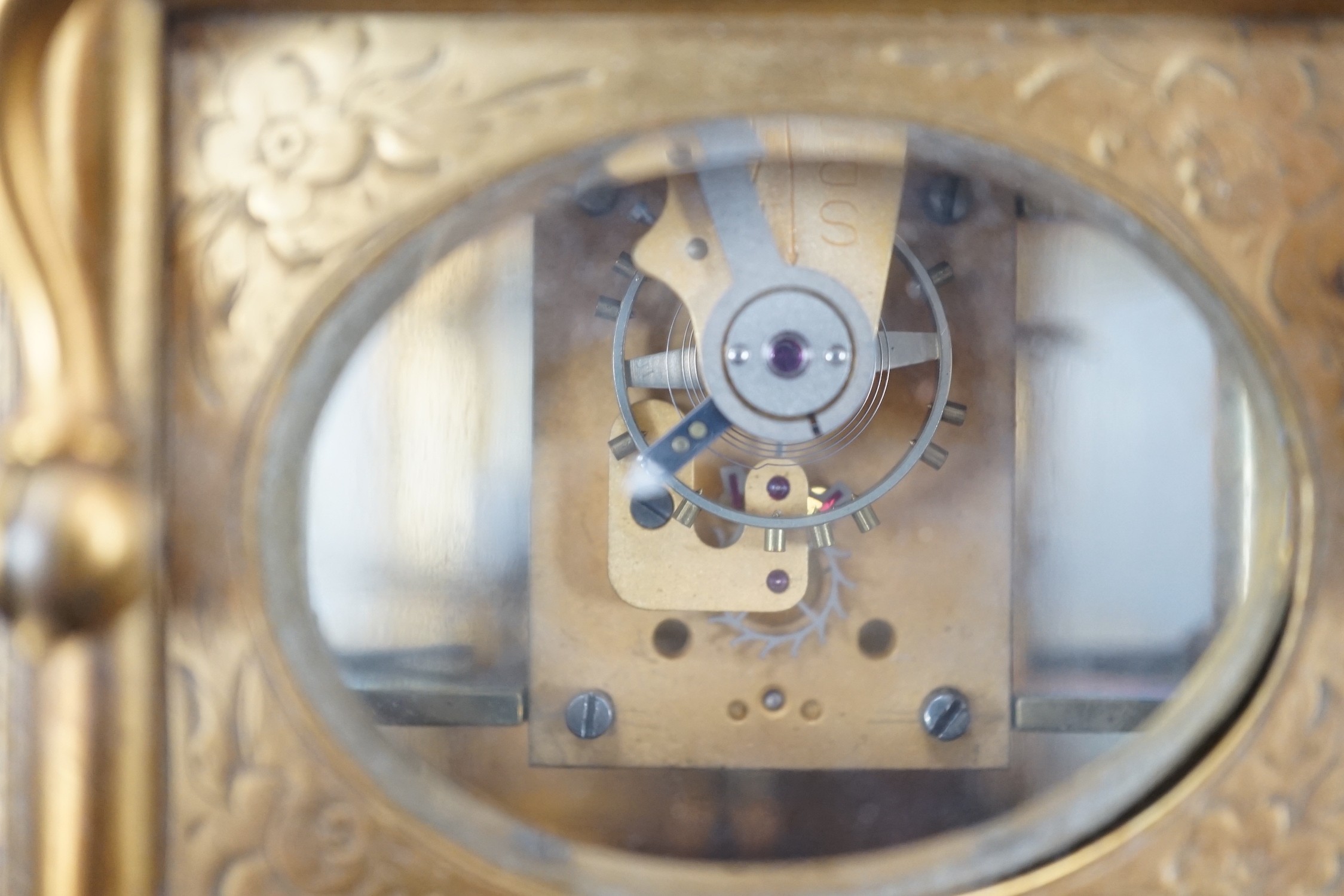 A late 19th century French eight day timepiece, in an engraved brass gorge case. 12cm tall